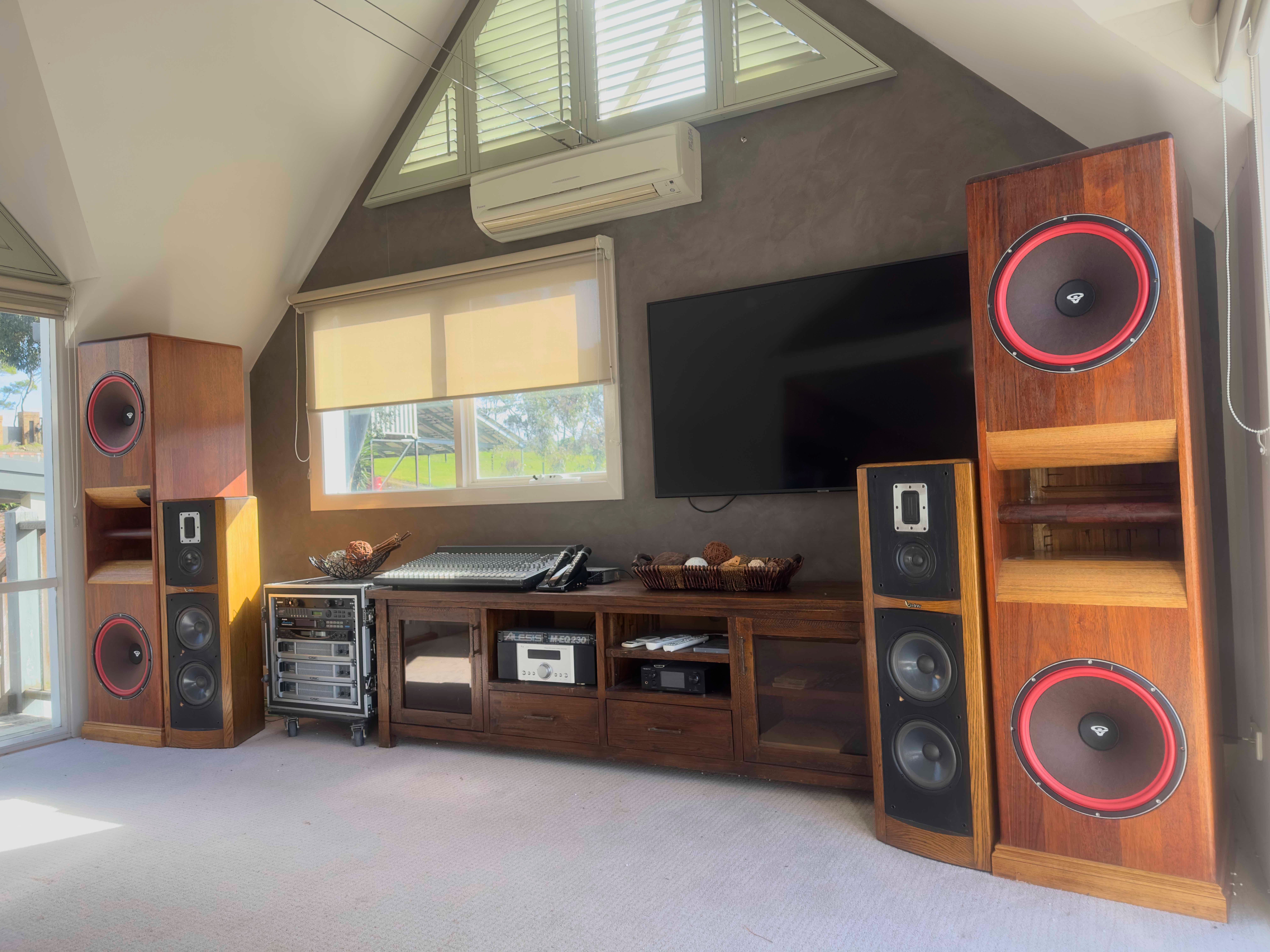 Custom built audio system with large wooden tower speakers and professional mixing equipment